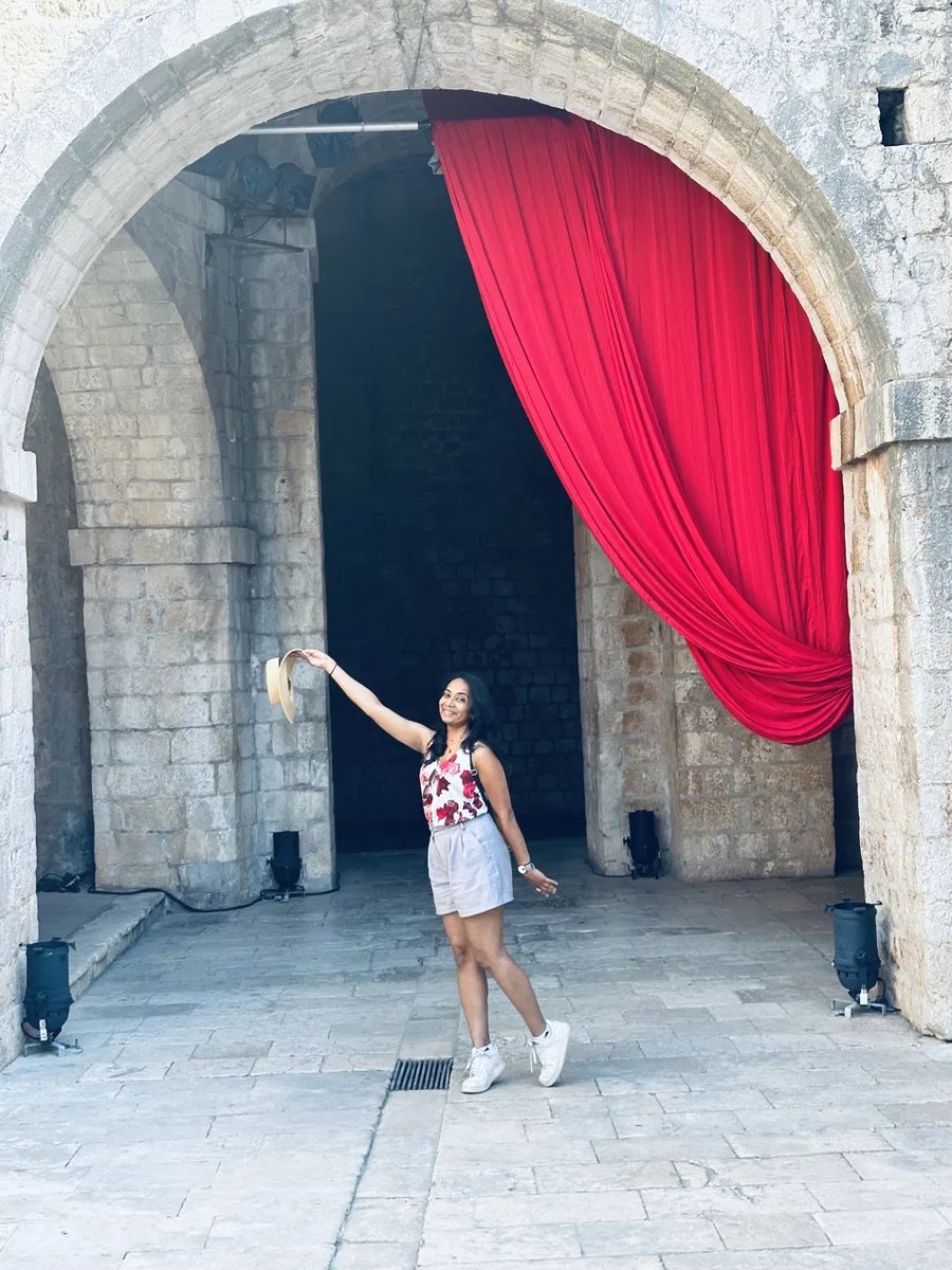 Playful photo under a red curtain archway in Dubrovnik