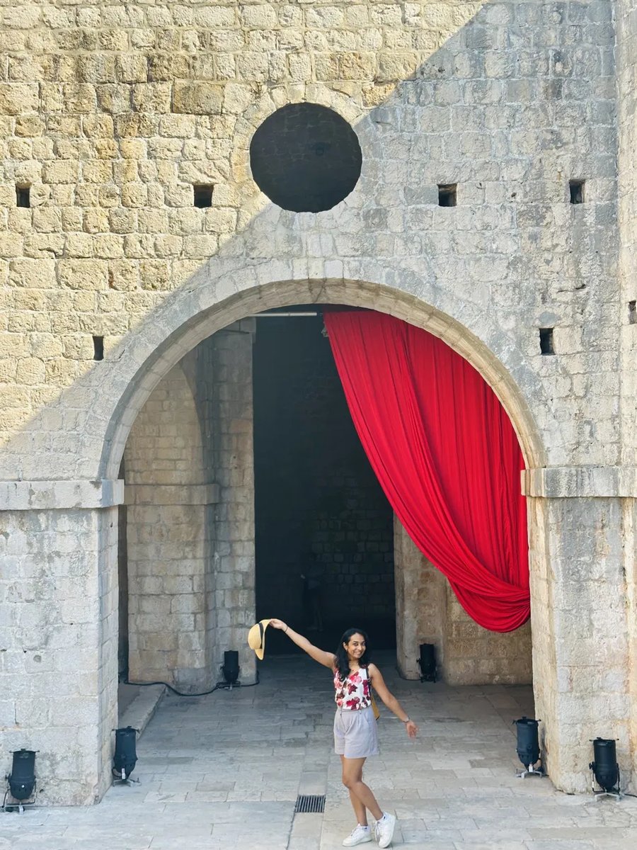 Playful photo under a red curtain archway in Dubrovnik